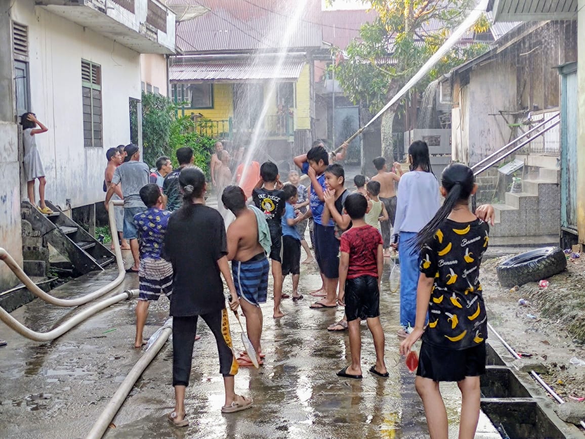 Cuaca Panas, Warga Jalan Pangeran Mas Kota Sanggau Semprotkan Air ke Atap Ruma